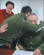  ??  ?? Forty-nine-year-old Lin Qingsong hugs Ren with gratitude after receiving his accordion certificat­e.