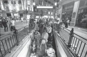  ?? PHOTOS BY DANIEL LEAL-OLIVAS / AFP ?? Passengers wait for a train inside Oxford Street tube station in the early hours of Aug 20 on the night of the launch of the 24-hour night tube service; passengers enter Oxford Circus tube station in central London; people take a ride in a taxi-bike...