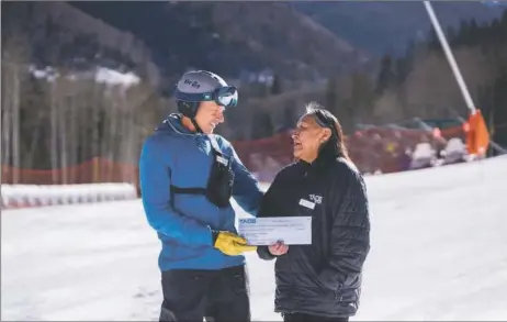  ?? COURTESY OF TAOS SKI VALLEY ?? Taos Ski Valley CEO David Norden presenting Margaret Romero of Taos Pueblo with a check for $25,000 in 2021. The money was used to launch the Charles N. Romero Snowsports program, part of the resort's initiative to work more closely with the tribe.