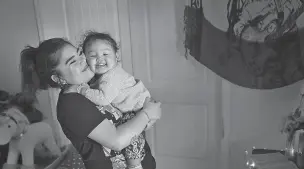  ?? ROSS D. FRANKLIN/ASSOCIATED PRESS ?? From left, Seanna Leilani Chavez, holds Athena Chavez, 2, the sister and daughter of Aaron Francisco Chavez respective­ly, as the two stand next to a shrine for Aaron at the family home in Tucson, Ariz. Aaron Chavez died of a fentanyl overdose at the age of 19, by taking ‘Mexican oxy,’ a form of fentanyl that is potentiall­y very leathal.