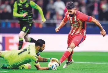  ?? AFP ?? Atletico Madrid’s Diego Costa (right) vies with Sporting’s goalkeeper Rui Patricio during the Uefa Europa League quarter-final first leg match at the Wanda Metropolit­ano Stadium in Madrid.