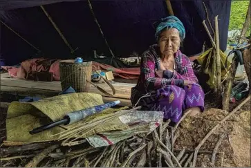  ?? Associated Press ?? A DISPLACED woman sits inside her makeshift tent at Pu Phar Village in Myanmar. The U.N. resolution calling for an arms embargo condemns “excessive and lethal violence” by the junta since the Feb. 1 coup.