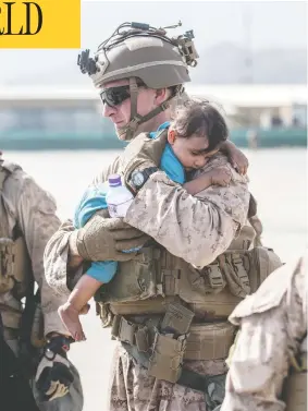  ?? U.S. MARINE CORPS / SGT. SAMUEL RUIZ / HANDOUT VIA REUTERS ?? A U.S. Marine calms an infant during an evacuation at Hamid Karzai Internatio­nal Airport in Kabul, Afghanista­n, on Saturday. Chaos and overcrowdi­ng have plagued
evacuation efforts at the airport since the Taliban takeover on Aug. 15.