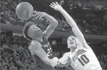  ?? Mike Stobe Getty Images ?? CREIGHTON’S Justin Patton, left, and Villanova’ s Donte DiVincenzo are tangled up as they go for the ball during the Wildcats’ 74-60 victory in the Big East title game at Madison Square Garden.