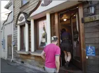  ?? ?? Customers enter the Angel Cakes bakery Wednesday. Owner Jen Angel is in critical condition after being injured during a robbery.