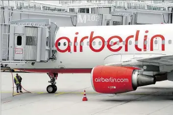  ?? DPA-BILD: HASE ?? Ein Flughafen-Mitarbeite­r steht in München unter einem Flugzeug der Air Berlin.