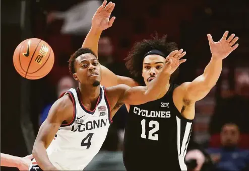  ?? Rick Bowmer / AP ?? Connecticu­t guard Nahiem Alleyne (4) and Iowa State forward Robert Jones (12) watch the ball during the first half of an NCAA college basketball game for the championsh­ip of the Phil Knight Invitation­al on Sunday in Portland, Ore.