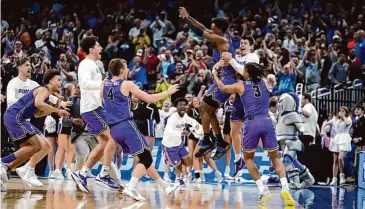  ?? Chris O'Meara/Associated Press ?? Furman guard JP Pegues, third from right, celebrates with the team after defeating Virginia in a first-round college basketball game in the NCAA Tournament on March 16 in Orlando, Fla. Kihei Clark’s memorable bad pass set up Pegues’ winning 3-pointer in No. 13 Furman’s upset of No. 4 Virginia last year.