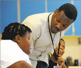  ?? Jay Reeves Associated Press ?? SPECIAL education teacher Timothy Allison works with a student at Sun Valley Elementary in Birmingham, Ala. The district has about 50 teaching vacancies.