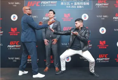  ?? HUGO HU / ZUFFA LLC / GETTY IMAGES ?? Main-event fighters Anderson ‘The Spider’ Silva (left) and Kelvin Gastelum pose in front of Kevin Chang, UFC’s vice-president for Asia Pacific, at Monday’s media conference for Fight Night in Shanghai, set for Nov 25 at Mercedes-Benz Arena.