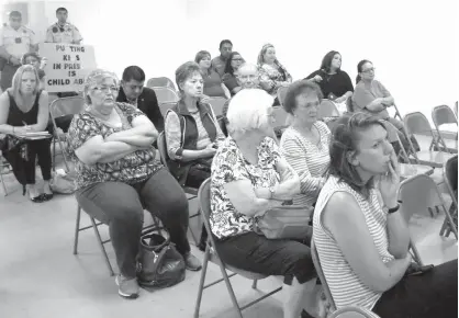  ?? Los Angeles Times/TNS ?? Residents of Jim Wells County, Texas, listen to comments during a public meeting about a proposal from a British correction­al company to turn an abandoned nursing home into a family immigrant detention center. It would employ 200 people.