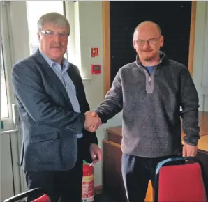  ??  ?? Crofting Commission­er Iain MacIver congratula­tes Dennis McGonnell on securing his new tenancy.