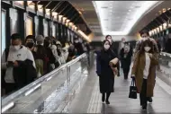  ?? (AP/Hiro Komae) ?? Commuters head toward a train station Friday evening in Tokyo.