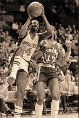  ?? (AP file photo) ?? Former Arkansas All-American Sidney Moncrief (4) puts up a shot in front of his former Razorbacks teammate Ron Brewer during an NBA game in 1983. Moncrief averaged 15.6 points per game during an 11-year NBA career and was named the league’s defensive player of the year in 1983 and 1984, the first two years of the award. His number was retired by the Milwaukee Bucks in 1990.