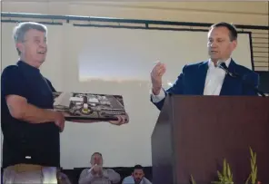  ??  ?? Mayor Rick Elumbaugh, right, presents Dr. Bill Beller, a longtime supporter of developing a community center in Batesville, with a canvas featuring a photo of the new center and the first membership ID card.