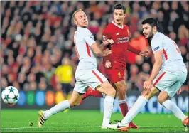  ??  ?? Liverpool's Philippe Coutinho (C) plays the ball between Spartak Moscow's Denis Glushakov (L) and Serdar Tasci at Anfield in Liverpool.