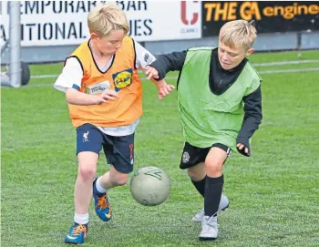  ??  ?? A keenly-contested tussle in the 8-12-year-old group at the recent Leisure and Culture Dundee Football Camp at the GA Arena.