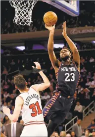 ?? Elsa / Getty Images ?? The Knicks’ Mitchell Robinson takes a shot as the Bulls’ Tomas Satoransky defends in New York’s 125- 115 victory at Madison Square Garden on Saturday.