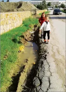  ??  ?? Children walking to school on the road with the absence of a pavement face dangerPhot­o: Meyil Avcan