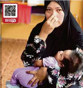  ?? (Foto Muhaizan Yahya/bh) ?? Norina memangku anak mereka yang baru berusia 51 hari ketika ditemui di Taman Jaya Delima, Tanjung Rambutan, Ipoh, semalam.