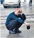  ??  ?? A man weeps as he crouches down outside the retail centre in Kemerovo