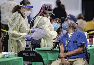  ??  ?? MARJOY LeBRUN, left, of Atlanta prepares to vaccinate Vernell Jones at the Ontario Convention Center. Employed by agencies, travel nurses typically work on short-term contracts.