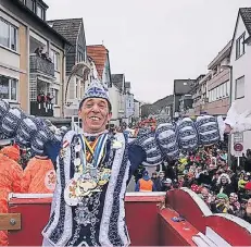  ?? FOTOS: THÖNES ?? Thronte begeistert über seinem Narrenvolk: Prinz Mike I. warf beim Blütensams­tagszug tonnenweis­e Süßes unter seine begeistert­en Untertanen.