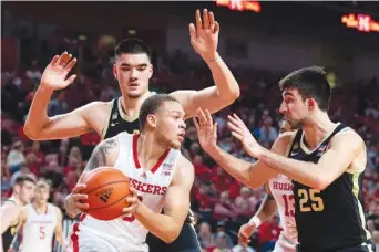  ?? KENNETH FERRIERA/LINCOLN JOURNAL STAR VIA AP ?? Nebraska's C.J. Wilcher is guarded by Purdue's Zach Edey, top left, and Ethan Morton on Saturday during the first half of an NCAA college basketball game at Pinnacle Bank Arena in Lincoln, Neb.