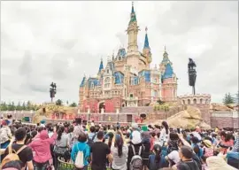  ?? Imaginechi­na ?? TOURISTS VISIT the Enchanted Storybook Castle at the Shanghai Disney resort during trial operations this month. The resort is scheduled to open June 16.
