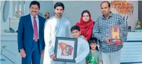  ?? — Agencies ?? Dubai Crown Prince Sheikh Hamdan (2nd L) with Abdullah Hussain (holding picture) and his family.