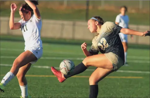  ?? Christian Abraham / Hearst Connecticu­t Media ?? Notre Dame of Fairfield’s Mackenzie Ledford (22) kicks away the ball as Joel Barlow’s Rachel Horowitz braces herself during their girls soccer game in Trumbull on Thursday.