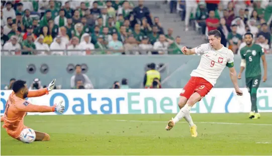  ?? — AFP ?? Poland forward Robert Lewandowsk­i (R) shoots and scores his team’s second goal past Saudi Arabia goalkeeper Mohammed al Owais (L) during the Qatar 2022 World Cup Group C match between Poland and Saudi Arabia at the Education City Stadium in Al Rayyan, west of Doha.