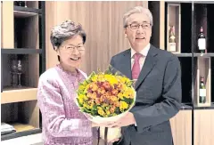  ??  ?? Deputy Prime Minister Somkid Jatusripit­ak, right, presents a bouquet to Carrie Lam, chief executive of Hong Kong yesterday.