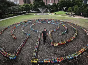  ?? Jon Shapley / Staff photograph­er ?? Artist Reginald Adams designed the “Discovery Labyrinth” at Discovery Green using colorfully painted cinder blocks filled with flowers.