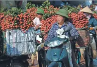  ?? AFP ?? Vietnam farmers wait to sell their litchi fruit to local traders at the market in Luc Ngan district in Vietnam’s northern province of Bac Giang.
