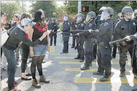  ?? Dan Coyro Santa Cruz Sentinel ?? POLICE SURROUND demonstrat­ors Feb. 12 at UC Santa Cruz during a labor protest by graduate teaching assistants on strike demanding cost-of-living raises.