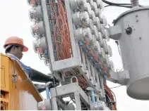  ??  ?? AN ELECTRICIA­N installs electric meters on a concrete post in Manila.