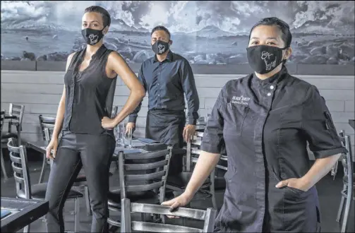  ?? L.E. Baskow Las Vegas Review-Journal @Left_Eye_Images ?? Jamie Tran, right, with Jesus Ramirez, center, and Jamie Clark at The Black Sheep wearing custom masks designed by bartender, Terry Clark.