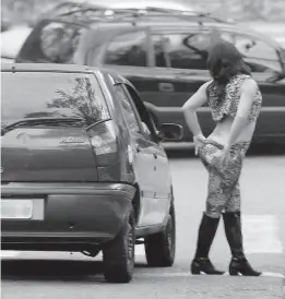  ??  ?? Travesti ao lado de carro de cliente na rua Estevão Dias Vergara (à esq.), no Parque do Carmo (zona leste de São Paulo), onde moradores espalharam faixas e cartazes em postes avisando que vão fotografar a atuação de prostituta­s e travestis e divulgar...