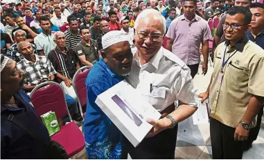  ?? — Bernama ?? Full of gratitude: BR1M recipient Harun Abu, 56, hugging Najib after receiving the aid during the event at the Sultan Ahmad Shah Convention Hall in Pekan.