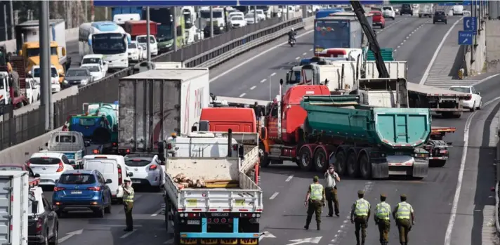  ?? ?? ► Un grupo de camioneros obstruyen autopista central y avenida Américo Vespucio, mientras carabinero­s dirigen el tránsito por congestión vehícular.