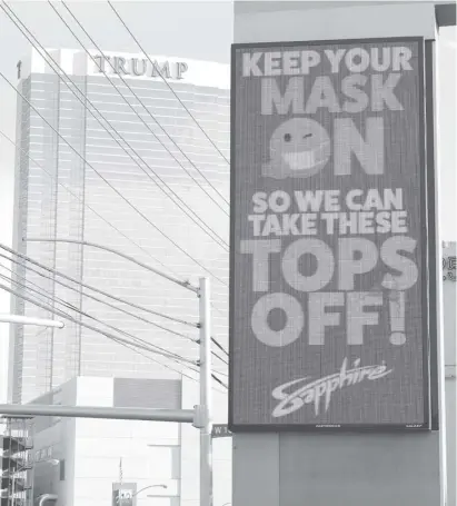  ?? ETHAN MILLER /AGENCE FRANCE-PRESSE ?? THE MESSAGE ‘Keep your mask on so we can take these tops off!’ is displayed at Sapphire Las Vegas Gentlemen’s Club billboard near the Trump Internatio­nal Hotel & Tower Las Vegas amid a surge of new coronaviru­s cases in the US in Las Vegas, Nevada.