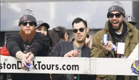  ?? Elise Amendola / Associated Press ?? The Red Sox’s Craig Kimbrel, left, Joe Kelly, center, and Bethel High graduate Matt Barnes catch beer cans tossed during a parade to celebrate the team’s World Series championsh­ip over the Los Angeles Dodgers on Wednesday in Boston.