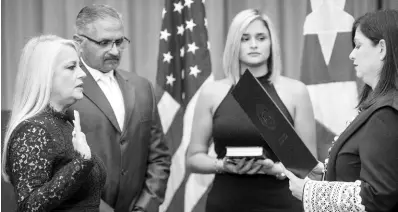  ?? AP ?? Justice Secretary Wanda Vázquez is sworn in as governor of Puerto Rico by Supreme Court Justice Maite Oronoz in San Juan, Puerto Rico, on Wednesday, August 7, 2019. Vázquez took the oath of office early Wednesday evening at the Puerto Rican Supreme Court, which earlier in the day ruled that Pedro Pierluisi’s swearing in last week was unconstitu­tional. Vázquez was joined by her daughter, Beatriz Diaz Vázquez, and her husband, Judge Jorge Diaz.