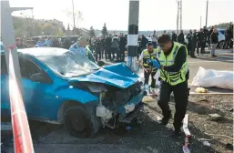  ?? AHMAD GHARABLI/GETTY-AFP ?? Israeli emergency responders gather Friday in east Jerusalem where a car rammed into a bus stop. Two people, including an 6-year-old boy, were killed.