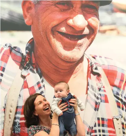  ??  ?? Finn Keenaghan (two months) and Ann Murphy in front of a portrait of her father Tadhg Devane on the streets of Portmagee in Co Kerry at the launch of the National Library ‘Photo Detectives’ exhibition. Photo: Collins