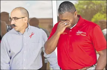  ?? HYOSUB SHIN / HSHIN@AJC.COM ?? Capt. James Minta (left), senior naval science instructor, comforts 1st Sgt. Lorenzo Cox as he gets emotional about his students, who were killed when their vehicle struck a Fulton County school bus on Ga. 92 on Monday.