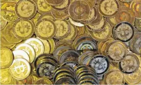  ?? ASSOCIATED PRESS FILE PHOTO ?? Bitcoin tokens are seen at Mike Caldwell's shop in Sandy, Utah, in April 2013. The price of bitcoin, the most widely used virtual currency, rose above $10,000 on Wednesday for the first time, breaking a symbolic threshold in what has been a vertiginou­s...