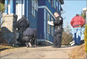  ??  ?? Officer Tony Pietrafesa looks at court documents calling for the ejection of the Merriman family by midnight on Sunday. Ron Merriman had to be escorted from the house by three officers.