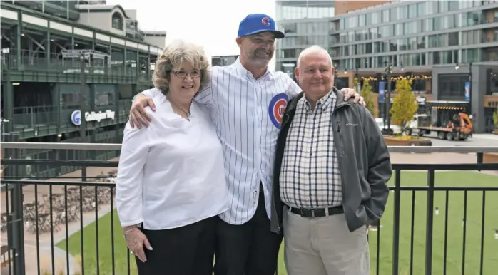  ?? DAVID BANKS/GETTY IMAGES ?? David Ross poses for photos with his mother, Jackie, and father, David, after being introduced as the Cubs’ manager on Oct. 28, 2019, at Wrigley Field. It’s Ross’ first job in a dugout.